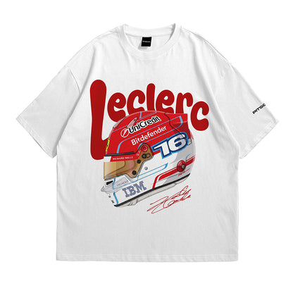 A white short-sleeve crewneck t-shirt featuring a graphic print of a red, white, and blue racing helmet with the name 'Leclerc' in large red letters across the chest, and an IBM logo on the lower part of the helmet.